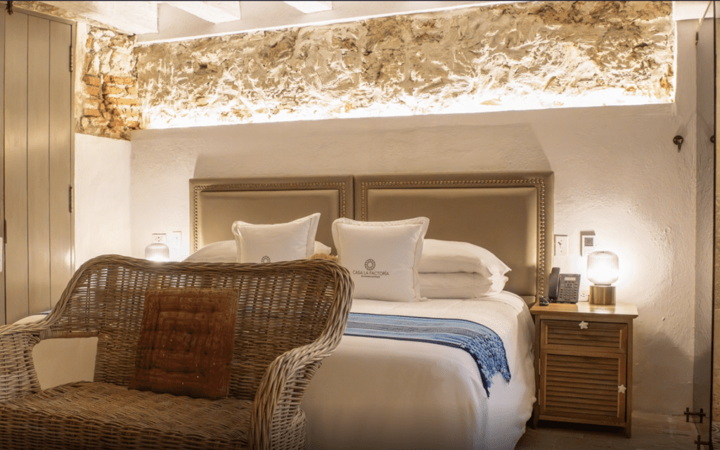 a bed with a wicker chair and a lamp