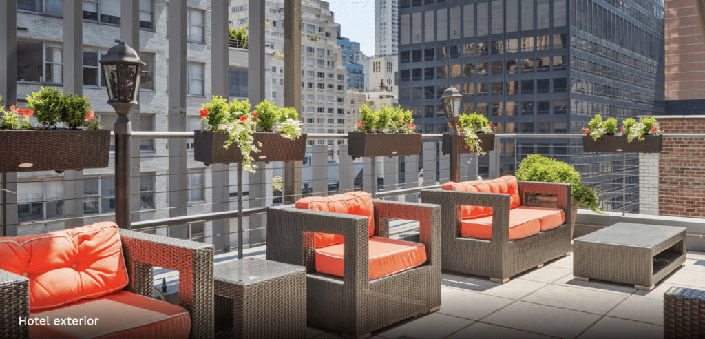 a group of chairs and tables on a balcony with a city view