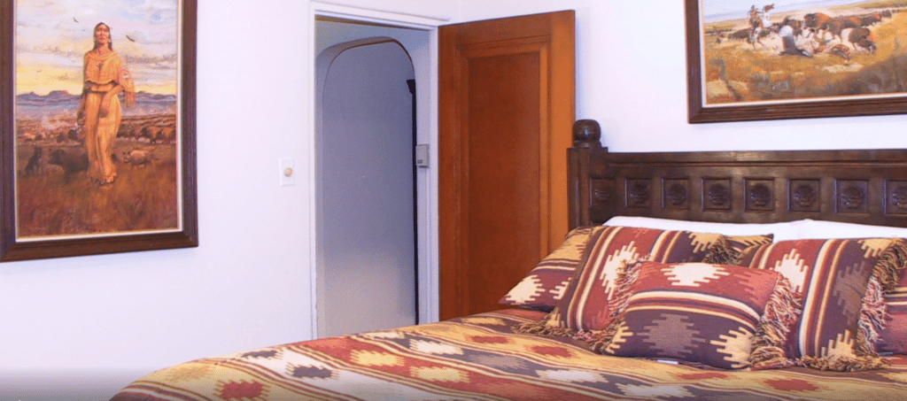 a bed with pillows and a wooden headboard next to a door