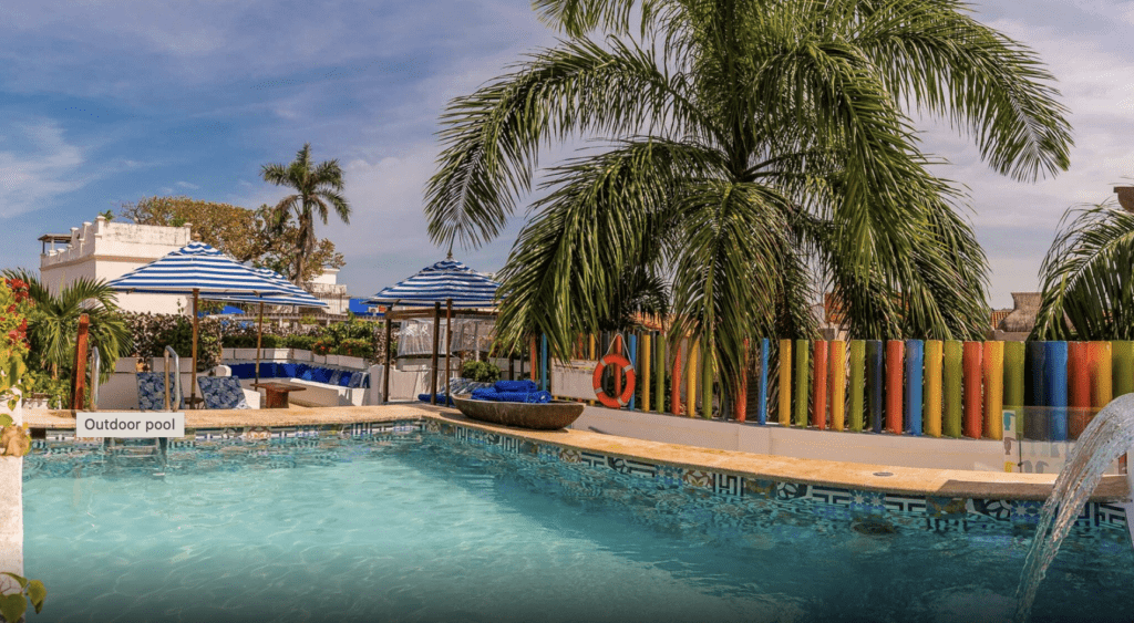 a pool with umbrellas and palm trees
