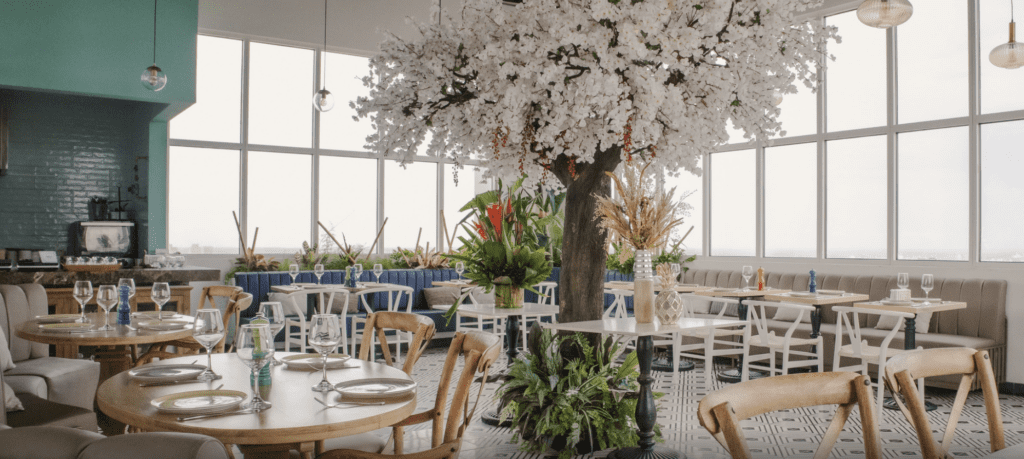 a room with tables and chairs and a tree