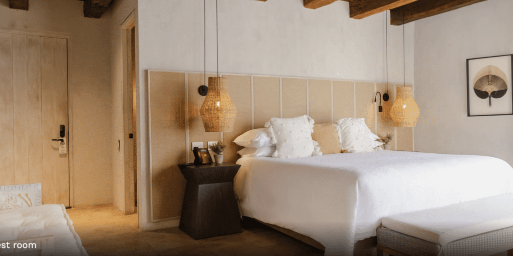 a bed with white sheets and pillows