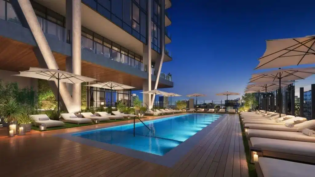 a swimming pool with umbrellas and chairs in front of a building