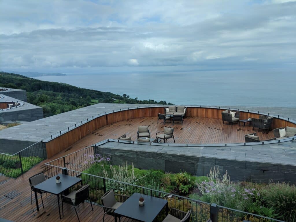 a deck with chairs and tables overlooking the ocean