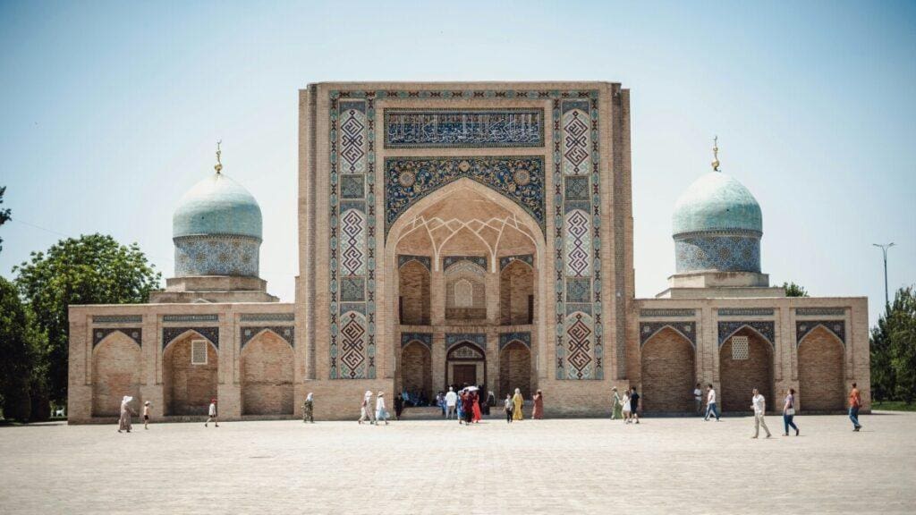a large building with blue domes and people walking around