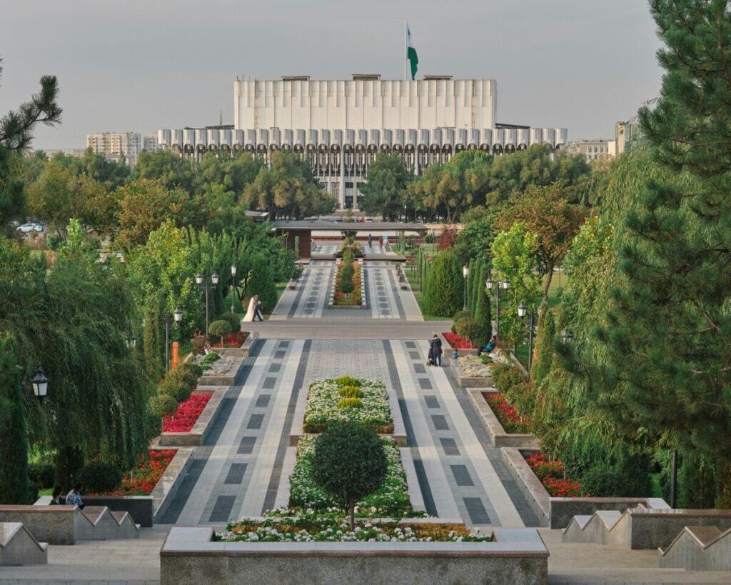 a walkway with trees and a building in the background