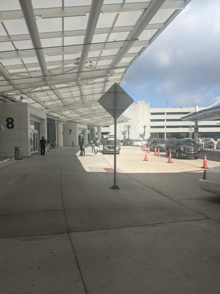 a building with a roof and cars parked in the parking lot